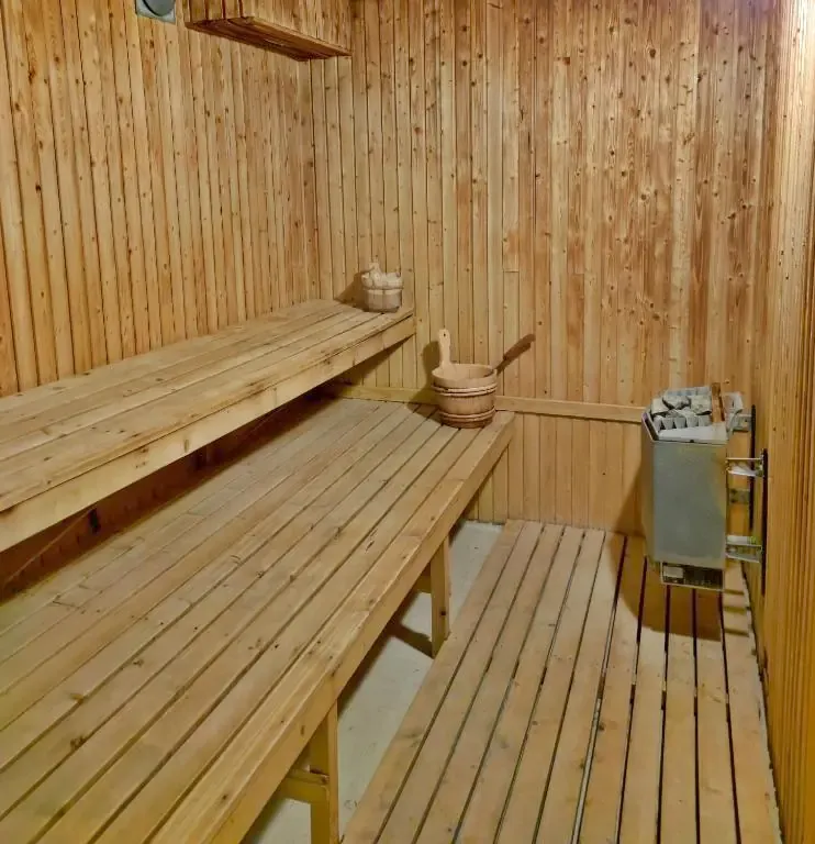 Bastu i ljust trä med lavar i två nivåer och bastuaggregat.